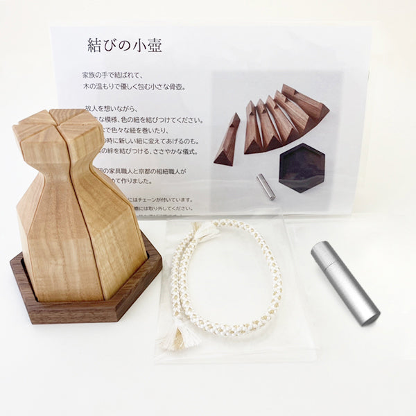 紐を結びつける、ささやかな儀式:納骨カプセルにご遺骨を納め、紐を結びつける小さな骨壺。故人への想いも木壺に込めていただけます。(イメージ:お包みナチュラル)