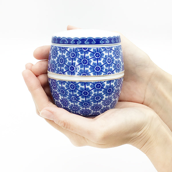 上品な陶器の艶：有田焼の様式の一つである、格調高い「鍋島様式」の分骨用お骨壷。立体を表現する、藍色の美しい稜線が描かれています。