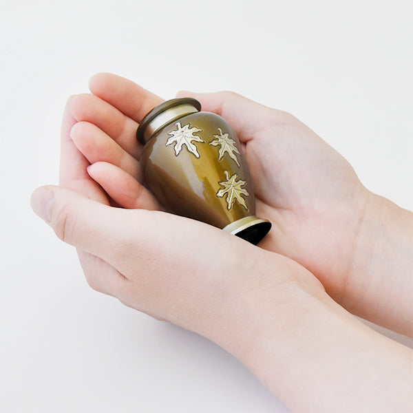 両手で包み込めるサイズ感：風に舞う楓をイメージした可愛いボトルのミニ骨壷メープル。華やかな色の分骨骨壷です。
